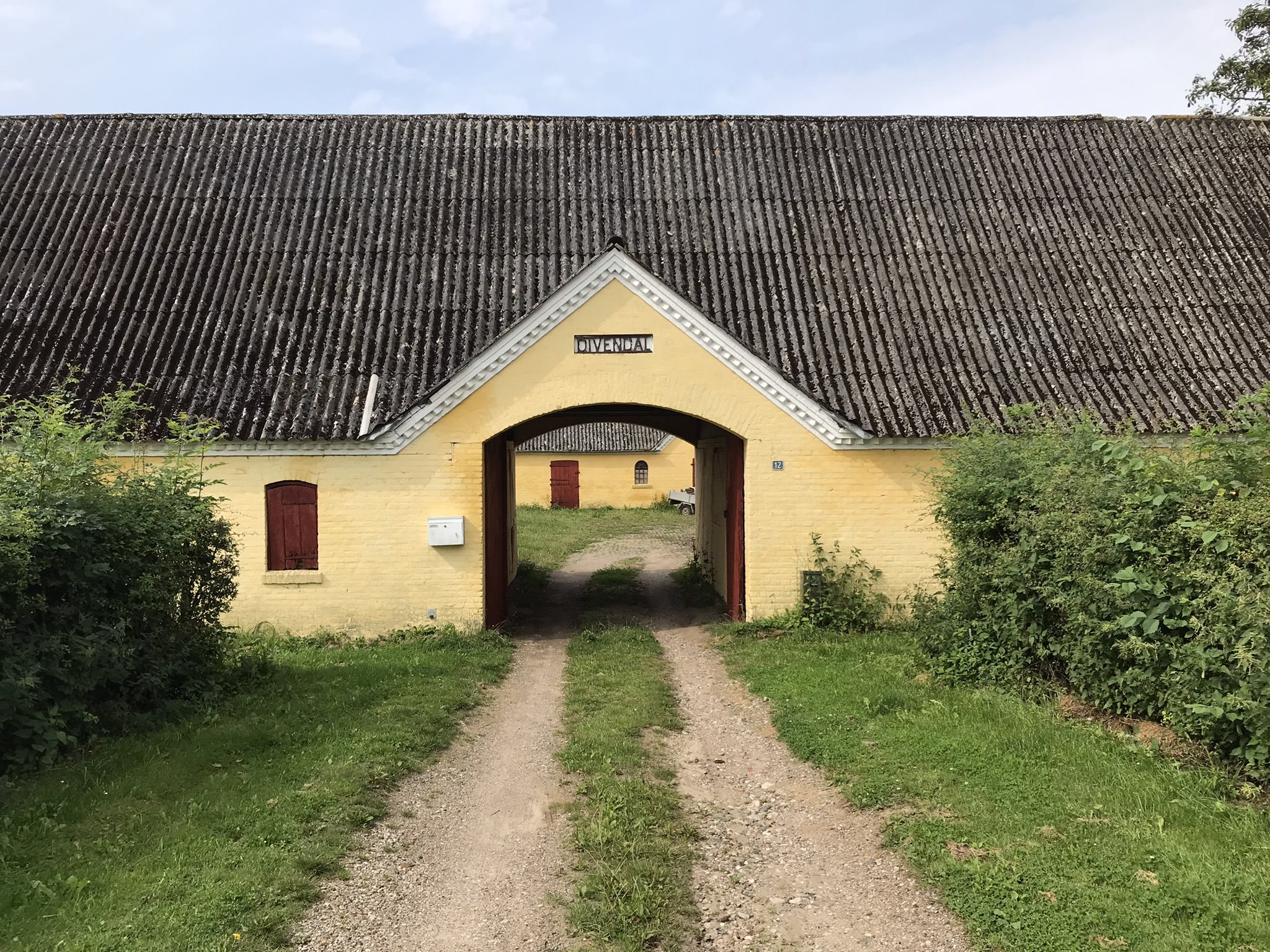 Fremhævet indkørsel med gårdnavn over porten billede i fuldskærmstilstand. Billede af Bjergegyden 12, Sønderby Bj, 5631 Ebberup