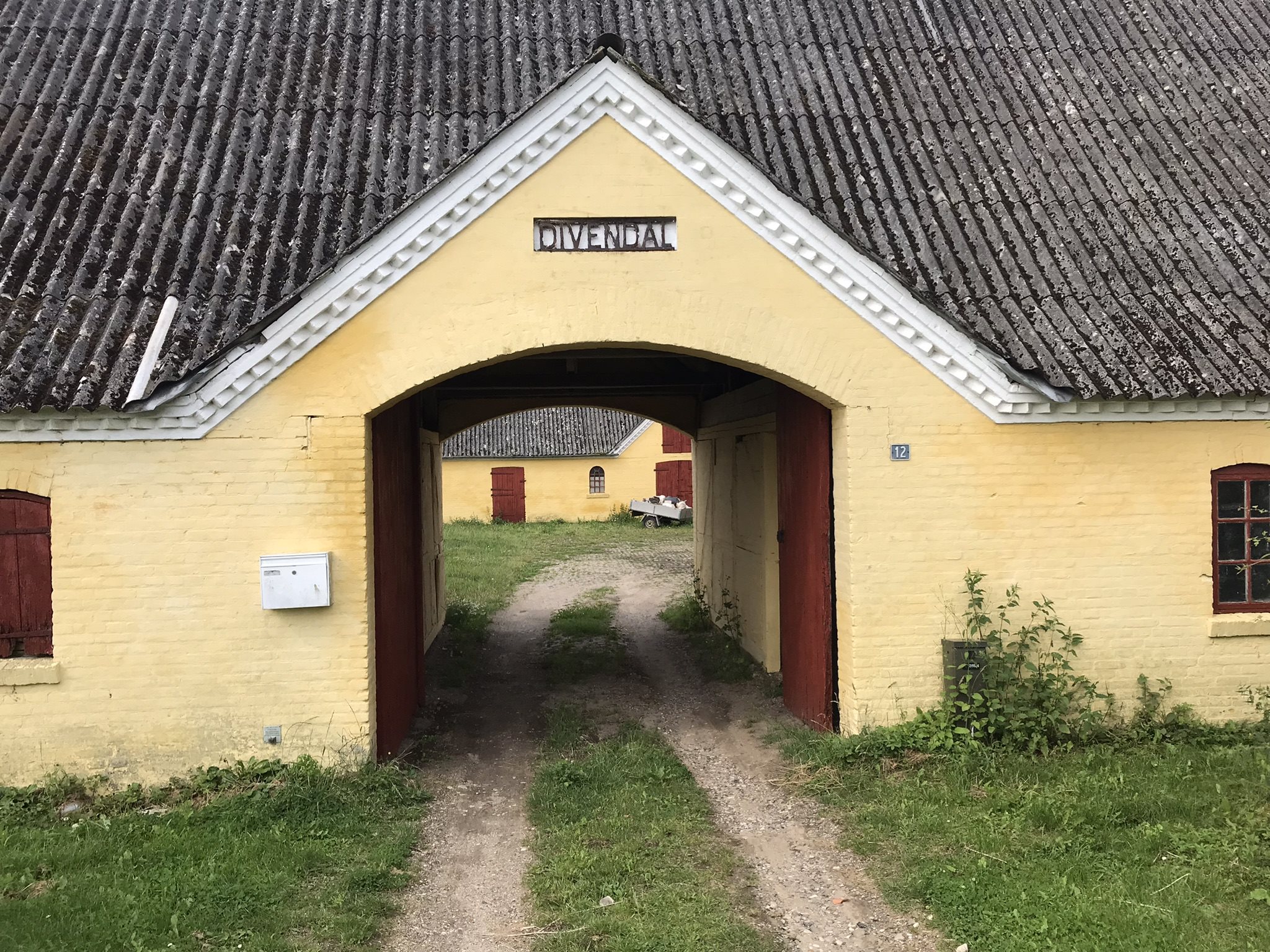 Fremhævet indkørsel med gårdnavn over porten billede i fuldskærmstilstand. Billede af Bjergegyden 12, Sønderby Bj, 5631 Ebberup